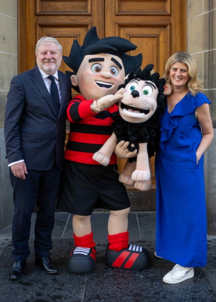 National Librarian and Chief Executive of the National Library of Scotland, Amina Shah and Cabinet Secretary for Constitution, External Affairs and Culture with Dennis the Menace outside the Library's George IV Bridge building. Credit: Neil Hanna