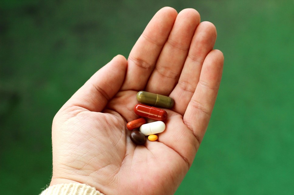 A hand holding a number of different pills. Copyright-free image