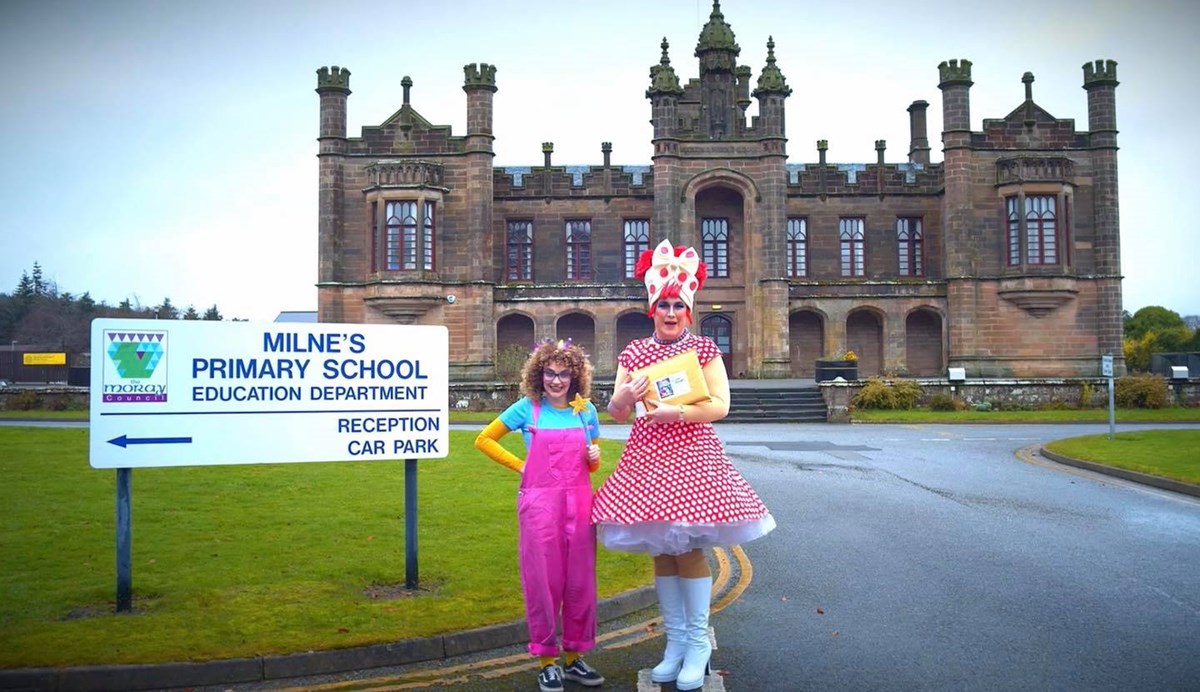 Out of the Darkness Theatre Company's Dame Deanie and Fairy Firth outside Milne's Primary School with DVD