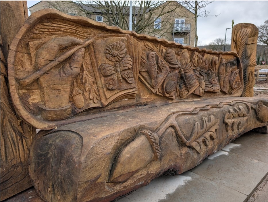 Otley bench unveiling carving 1: Close up photo of the new oak bench unveiled in Tittybottle Park, Otley