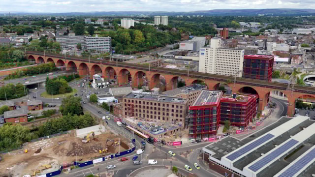 Drone shot of new bridge beam travelling by road in front of Stockport viaduct August 2025: Drone shot of new bridge beam travelling by road in front of Stockport viaduct August 2025