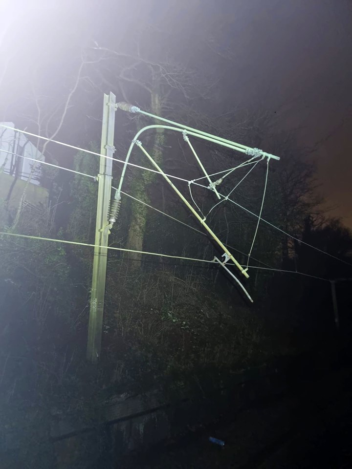 Twisted overhead line structure damaged by fallen tree at Styal night time