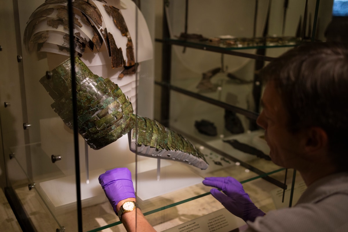 Dr Fraser Hunter installs the Roman arm guard in the Early People gallery at the National Museum of Scoltand. Image copyright Duncan McGlynn (8)