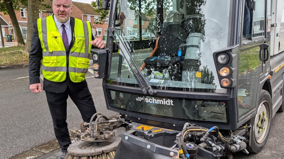 Cllr Damian Corfield with the roadsweeper carrying the new weed ripper arm