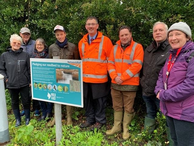 Network Rail pledges 16 acres of Norfolk reedbed to nature: Unveiling the partnership at Haddiscoe station. From left to right: station adopters Gerda Gibbs, Keith Watson and Julie Ann Reynolds; WildEast co-founder Hugh Somerleyton; Network Rail engineers Mark Walker and Liam Allen; Wherry Lines Community Rail Partnership officer Martin Halliday and Greater Anglia's Juliette Maxam