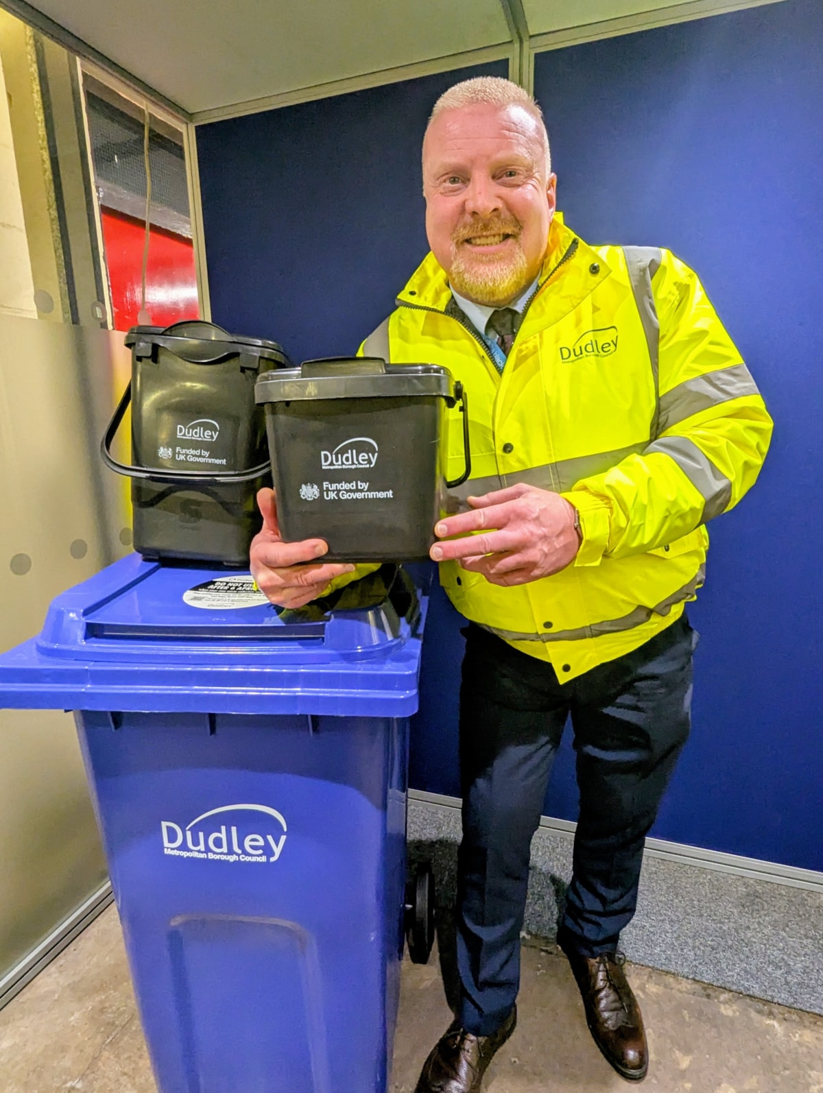 Cllr Damian Corfield with the new blue recycling bin and caddies for food waste