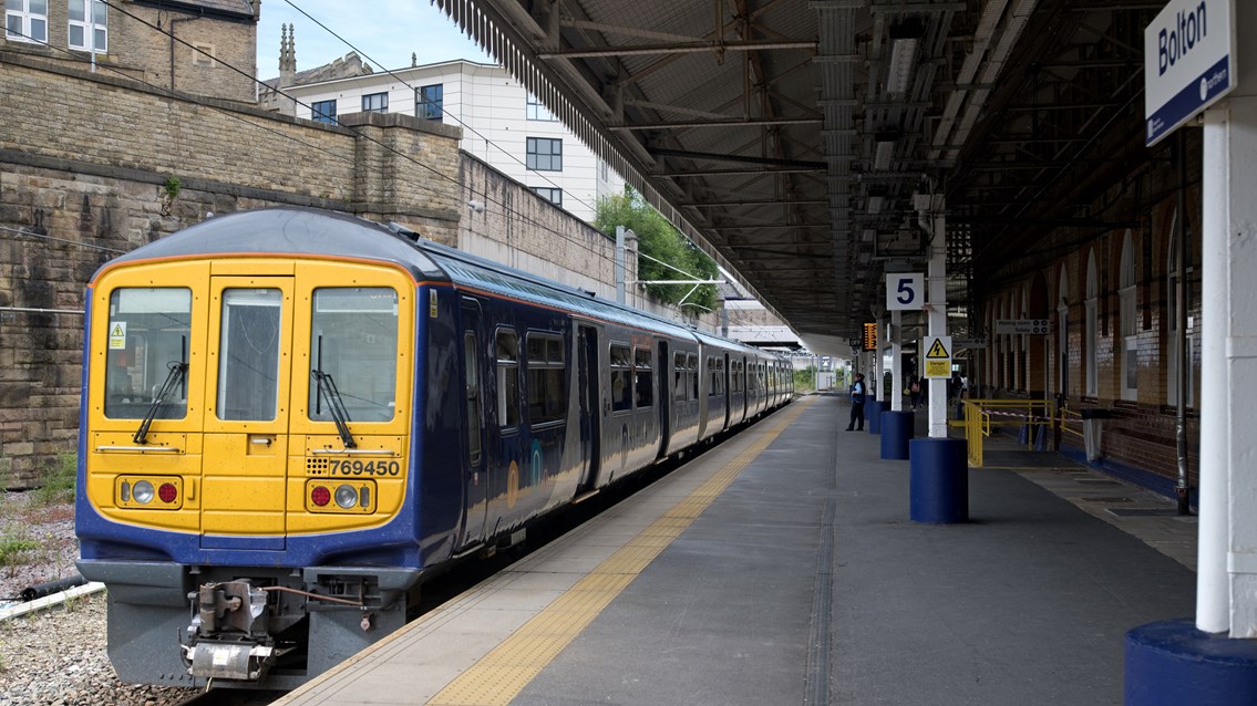 A Northern train stands at Bolton station cropped