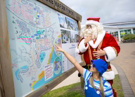 Santa and Elf study the park map at Hafan y Mor