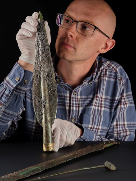 National Museums Scotland curator Dr Matthew Knight examines the Carnoustie Hoard. Photo © National Museums Scotland 1