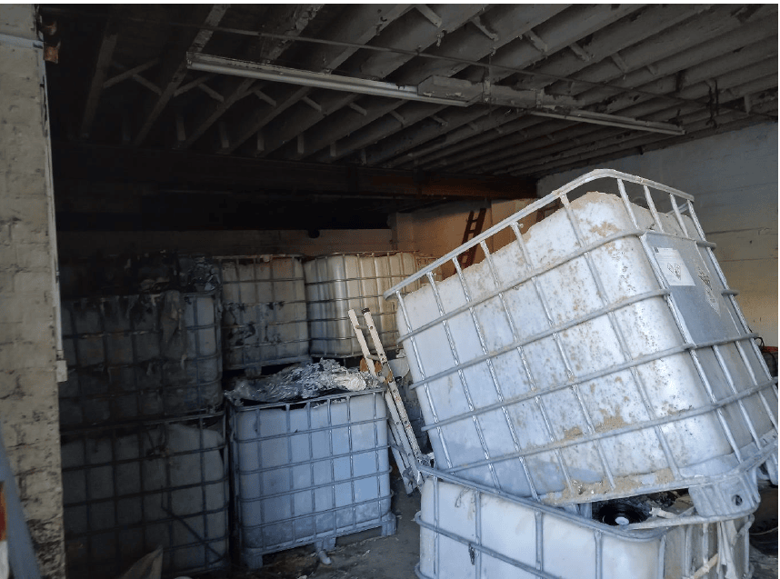 IBCs containing waste, namely stripped coatings, in left hand side of unit (as facing)