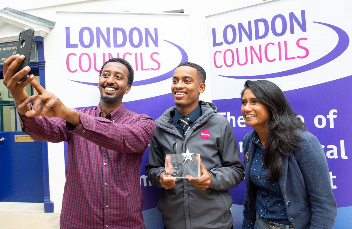 Usama Mohamed, centre, celebrates with Zak Hassan, a mentor at Jubba Youth Community Association, left, and Darshna Dhokia, Islington Council's youth employment and apprenticeships manager
