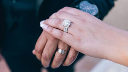 couple holding hands with wedding rings cropped