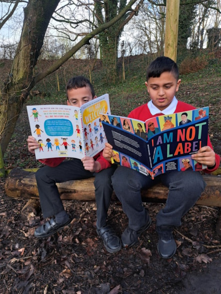 Year 6 pupils Manny (left) and Ayush reading in the forest school at Howick Church of England Primary School.jpg