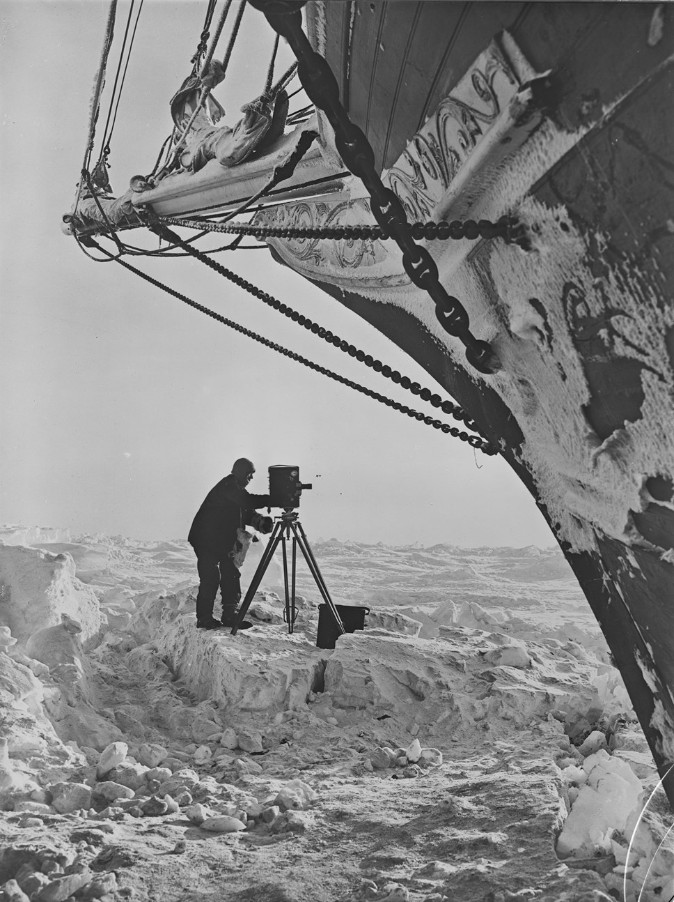S0000150-Frank Hurley with movie camera on the ice- beneath the bow of the 'Endurance'-2