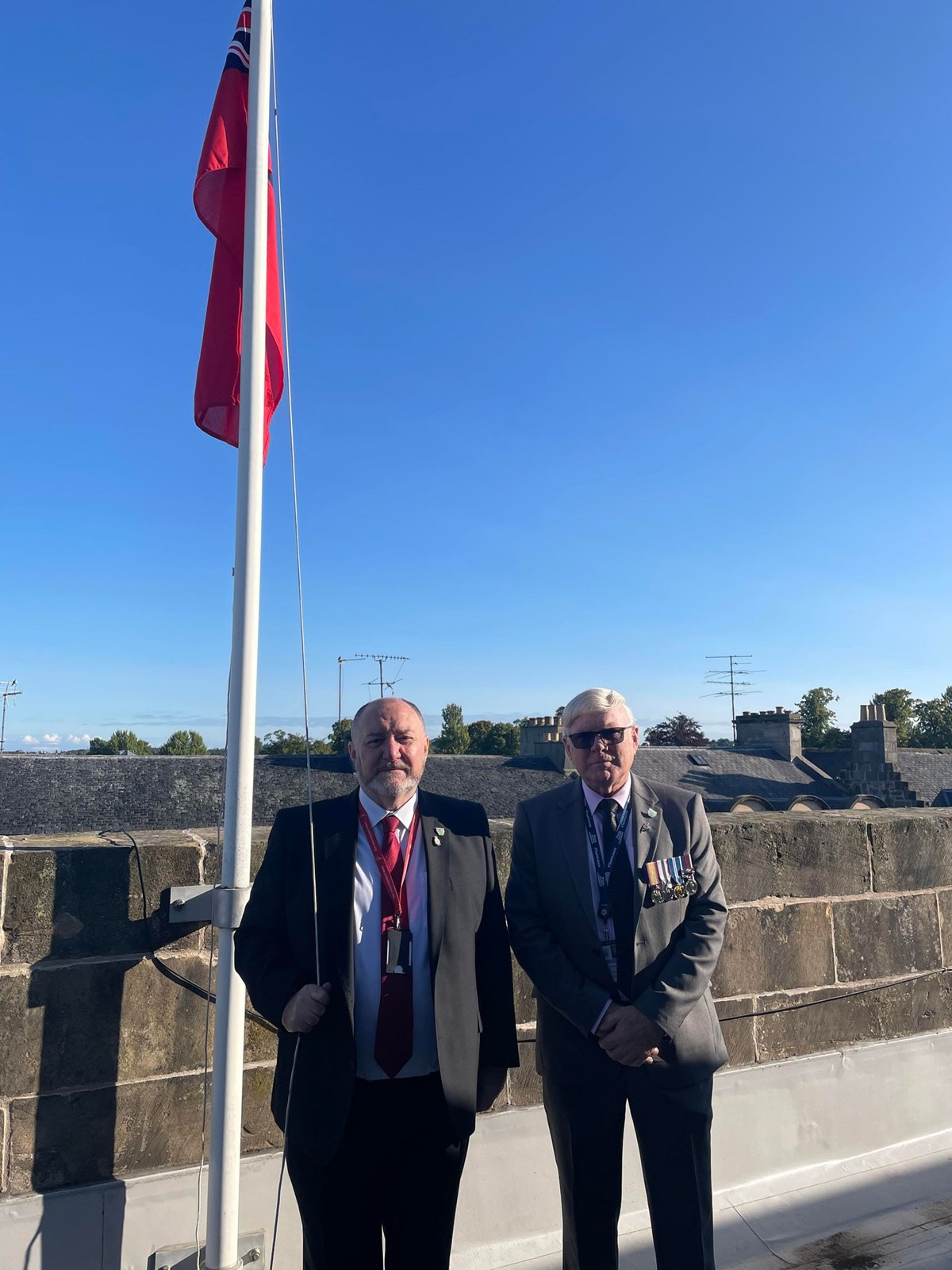 The council’s Royal Navy veteran – Cllr John Diver (left) stands with the council's Armed Forces and Veterans' Champion – Cllr Peter Bloomfield to raise the Red Ensign flag this morning (1 September) ahead of Merchant Navy Day on Sunday 3 September.
