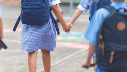children heading to school holding hands
