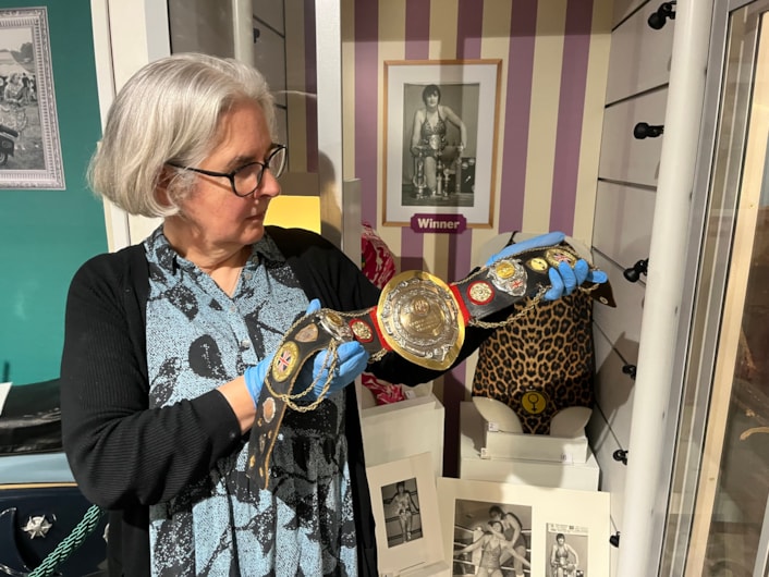 In the Picture: Curator Kitty Ross with a leotard and belt once worn by the city’s own female wrestler Sue Brittain, later known to opponents as Lady Satan.
Outside the ropes the pioneering grappler’s real name was Marjorie Farrar. She lived in Pudsey and throughout her career, fought a series of legal battles to be allowed to compete, including using equal opportunities legislation against the then Greater London Council during a two-day court hearing in 1979.