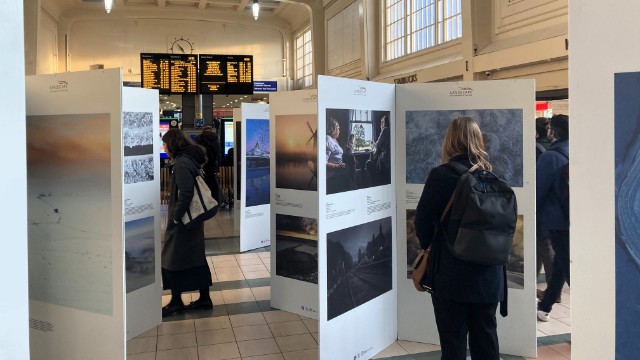 Passengers viewing the Landscape Photographer of the Year gallery on display at Leeds station, Network Rail