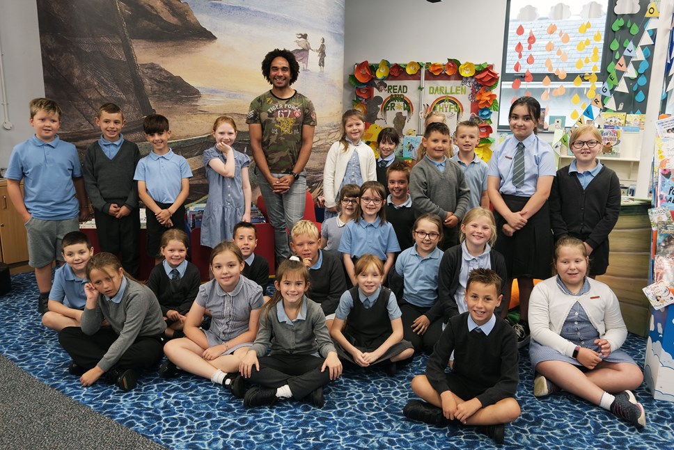 Joseph Coelho, Bardd Plant Waterstones, yn Llyfrgell Aberdaugleddau gyda phlant o Ysgol Sant Ffransis.