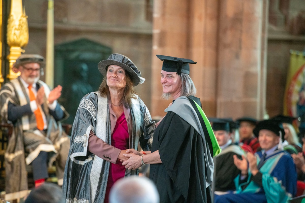 L-r Vice Chancellor Professor Julie Mennell shakes the hand of Hensman Prize winner Nina Albertelli during a graduation ceremony at Carlisle Cathedral on Wednesday 15 July 2026