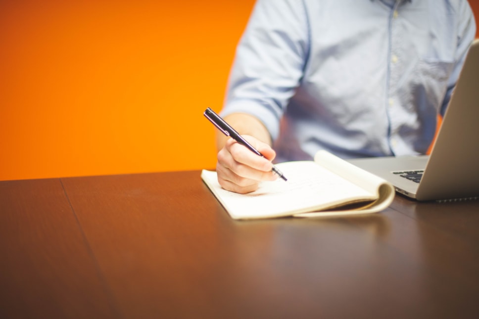 man with pen and laptop