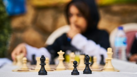 Girl playing chess outside