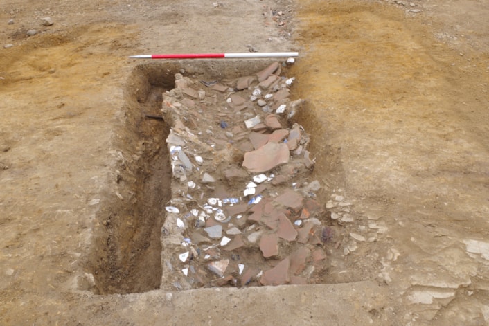 ELOR archive: Archaeologists excavate a drainage ditch with backfill of discarded late 18th to 19th century ‘rubbish’ items like broken pieces of ceramic or porcelain, animal bone, oyster shell, glass and fragments of building. Credit Wessex Archaeology.