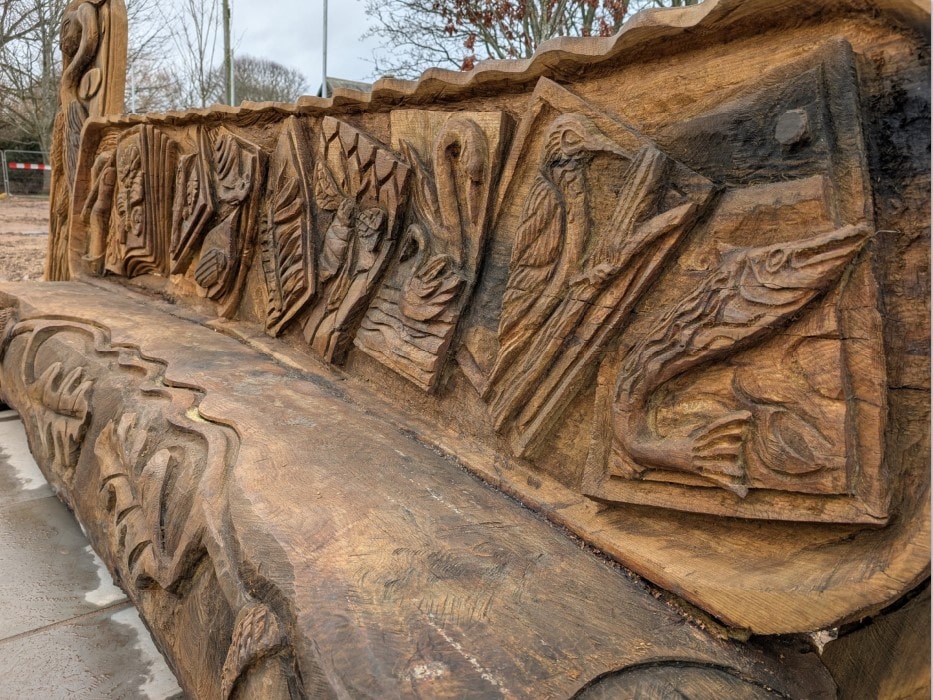 Otley bench unveiling carving 2: Close up image of the new oak bench in Tittybottle Park, Otley