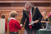 Cllr Davey presents a copy of the anthology to one of the children whose work was included
