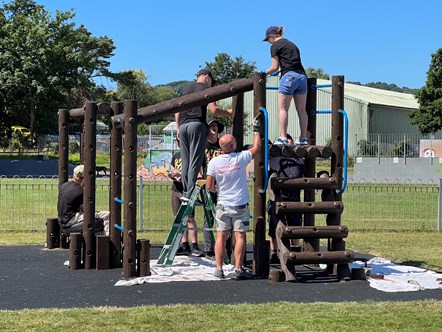 volunteers and Magna painting climbing frame