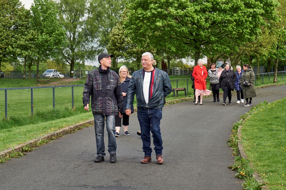 Men and women walking through a park