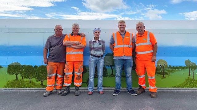 Rural mural makeover for railway bridge after village campaign: Contractors from Murphy's with Kath Almond from local action group at Meadow Lane bridge in Croston