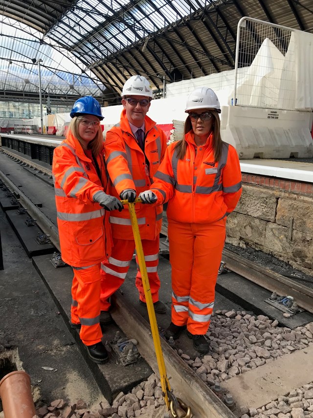 Glasgow Queen Street 4&5 - Margaret Hoey, ScotRail station manager for Queen Street,  Kevin McClelland, Network Rail route delivery director and Melanie Workman, Network Rail sponsor – Route Business Scotland: Representatives of the redevelopment team and station staff fit the final rail clip to the new track.