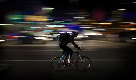 Cyclist riding through a town at night
