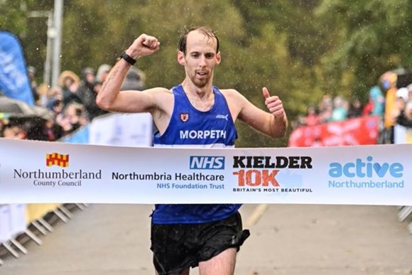 A man crossing the finish line of a race.