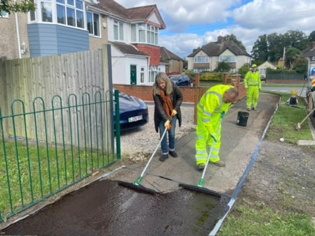 Councillor Karen Rowland and a member of the Council Highways team apply the pavement coating