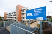 Wester Hailes HS pedestrian canal link: The new Wester Hailes High School building as viewed from the Union Canal entrance, featuring large signage directing visitors.