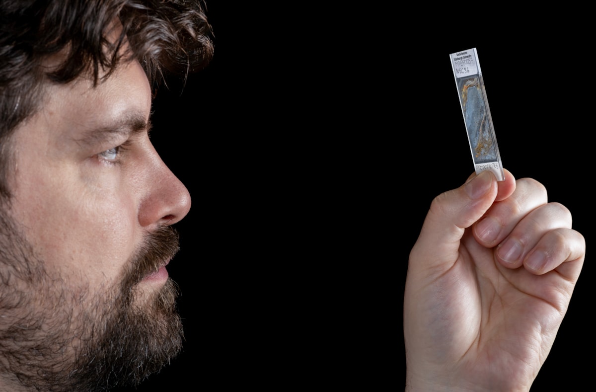 Corentin Loron from the University of Edinburgh with a slice sample of the fossil Prototaxites (credit Neil Hanna)