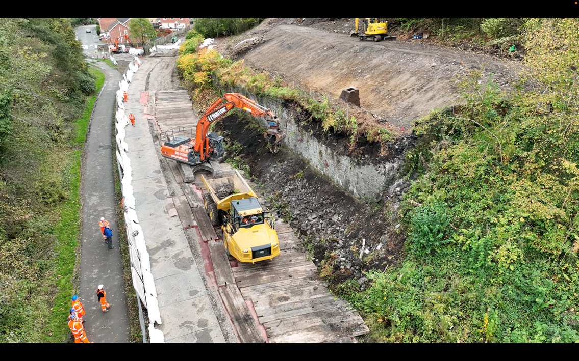 Digger removing retaining wall close up