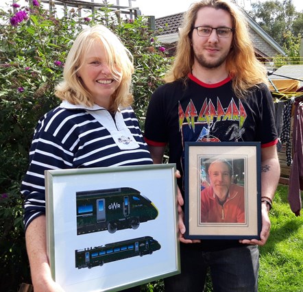 Iain Bugler's widow Kate and son Ed with a picture of Iain and his train illustration