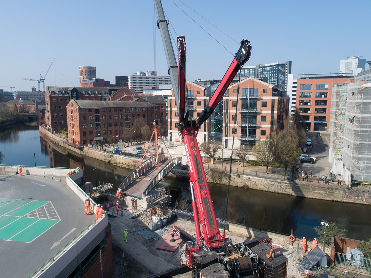 David Oluwale bridge installation: The David Oluwale bridge is lifted into place over the River Aire in Leeds. Engineers working on the David Oluwale bridge completed one of the project’s major milestones over the weekend, with cranes carefully placing the 40 tonne structure over the river where it will connect Sovereign Street to Water Lane. Credit BAM Nuttall.