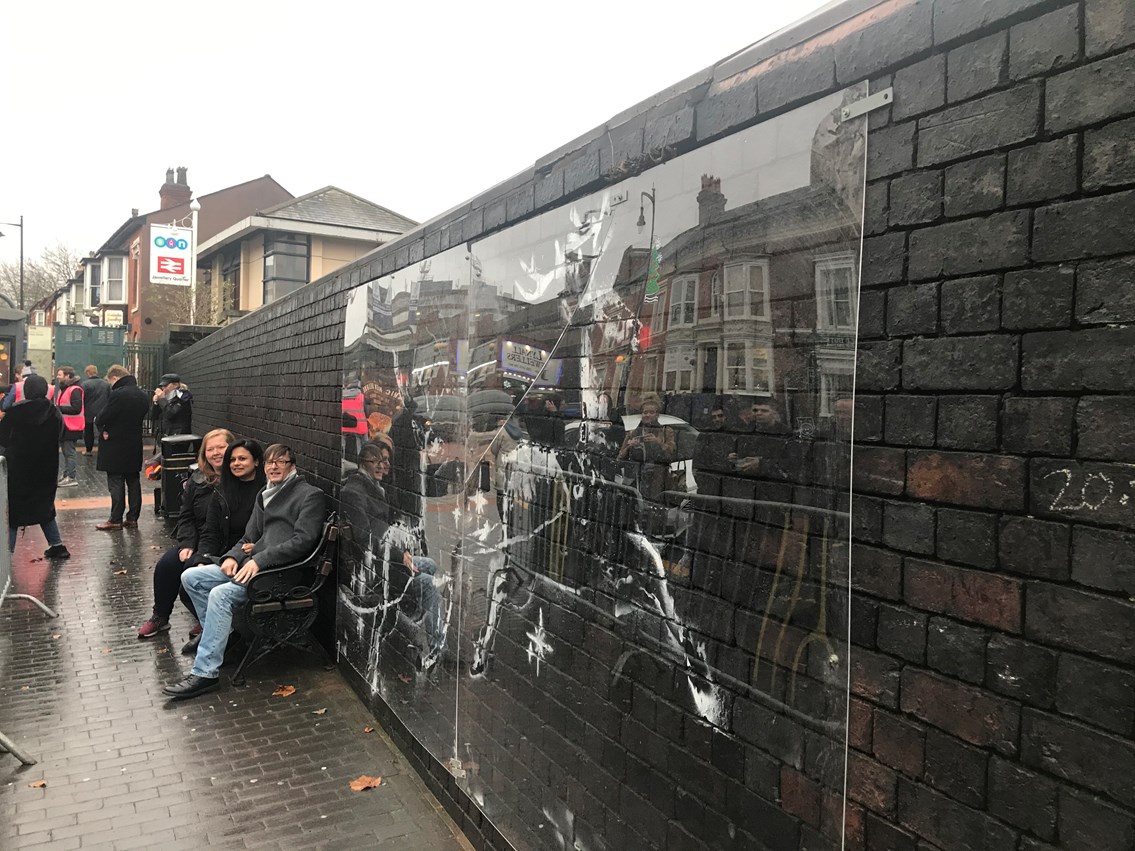 Visitors to the protected Banksy artwork in Birmingham