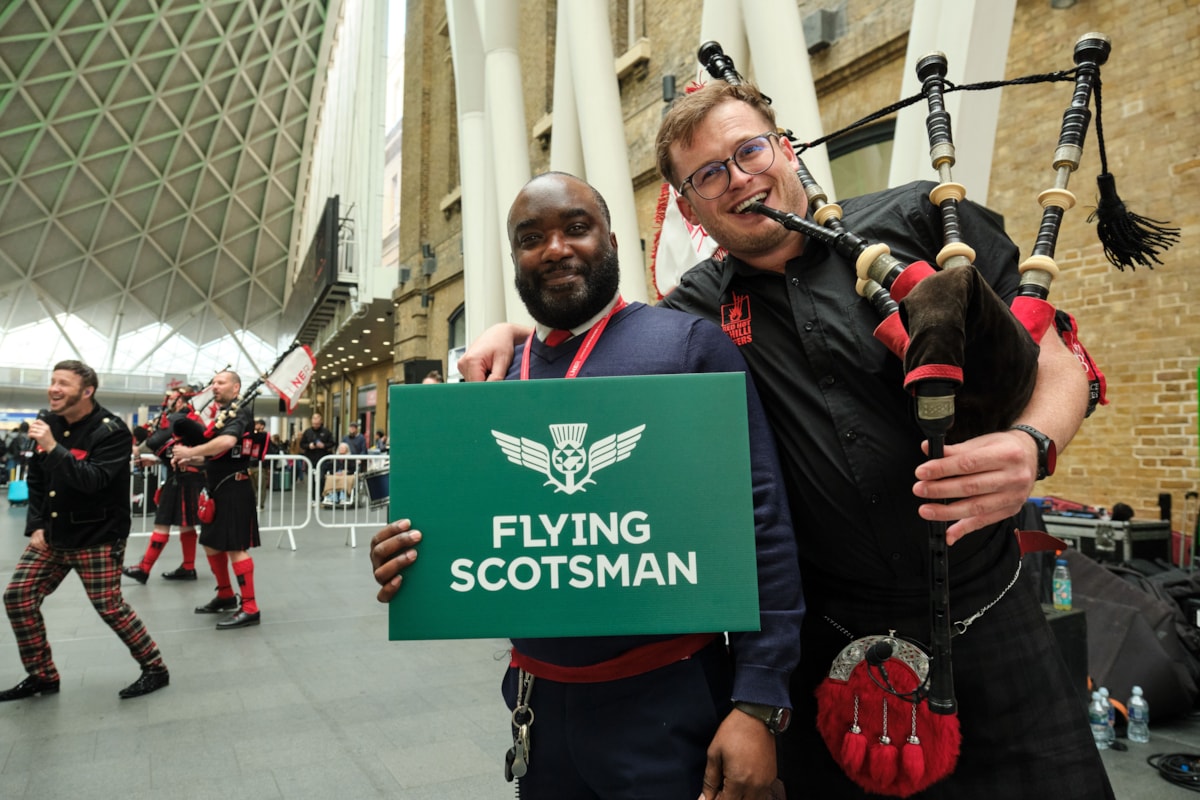 LNER COLLEAGUE WITH PIPER CELEBRATING THE FLYING SCOTSMAN SERVICE AT KINGS CROSS