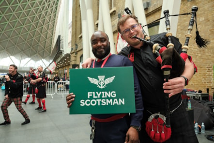 LNER COLLEAGUE WITH PIPER CELEBRATING THE FLYING SCOTSMAN SERVICE AT KINGS CROSS