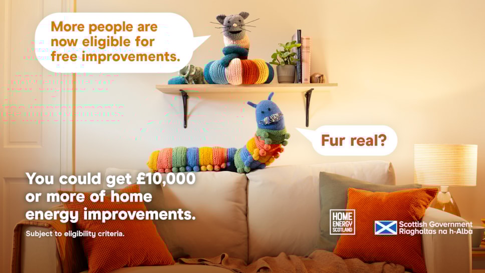 Home Energy Scotland promo image with knitted cat & caterpillar toys on a shelf. Speech bubbles say 'More people are now eligible for free improvements' and 'Fur real?'. Text below: 'You could get £10,000+ of home energy improvements. Subject to eligibility.
