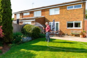 Picture of a man watering his back garden on a sunny day: Picture of a man watering his back garden on a sunny day