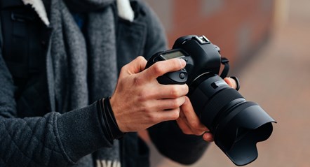 cheerful-young-man-looks-photos-camera-dressed-inwarm-stylish-jacket-grey-scarf