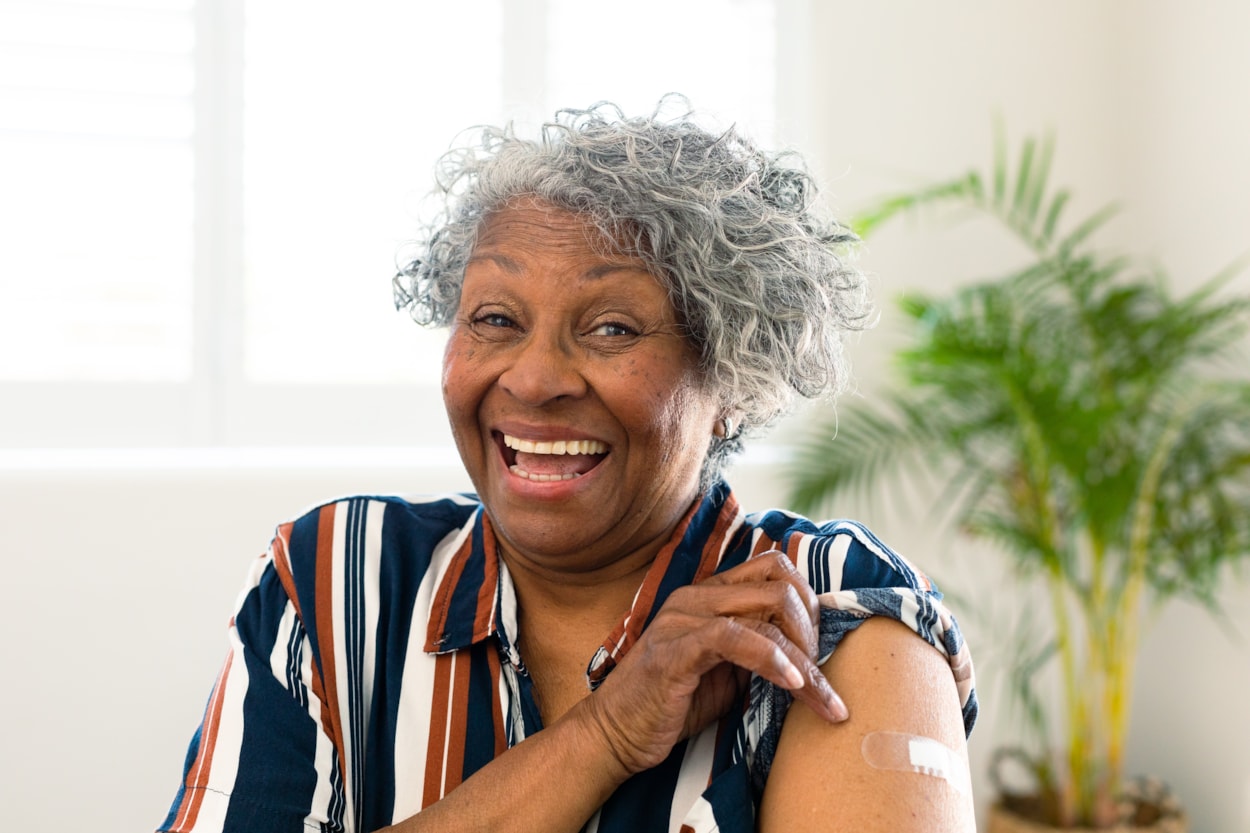 older-person-vaccine-bandage.jpg: Older lady showing off arm having been vaccinated