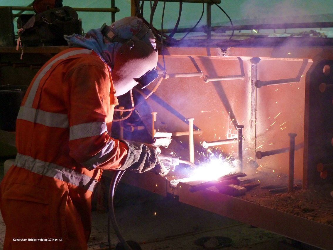 Sparks fly on Caversham bridge project!: A welder puts the finishing touches in place on the new 10,000-tonne bridge deck which will span Caversham Road and provide extra space for the additional tracks which will serve the four new platforms at Reading.