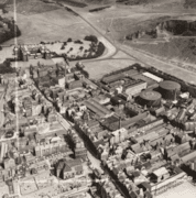 Aerial view of the Canongate area c. 1951 including Holyrood Palace, the Meadow Flat Gas Holders (now the site of Dynamic Earth) and Holyrood Brewery (now the site of the Scottish Parliament).: (c) Historic Environment Scotland